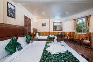 a bedroom with a large white bed with green pillows at Muscatel Roma - 400 Mts from Mall Road in Darjeeling