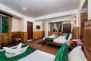 a hotel room with a bed and a tv at Muscatel Roma - 400 Mts from Mall Road in Darjeeling