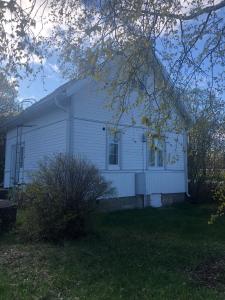 a white house with a tree in front of it at Small house central Parainen by Archipelago Trail in Pargas