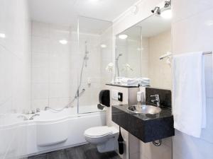 La salle de bains est pourvue d'un lavabo, de toilettes et d'une baignoire. dans l'établissement Fletcher Hotel-Restaurant Arneville-Middelburg, à Middelbourg