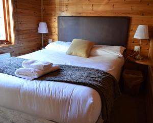 a bedroom with a bed with two towels on it at Woolpack Lodge in Holmrook