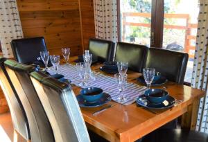 a wooden table with chairs around it with glasses on it at Woolpack Lodge in Holmrook +9 photos