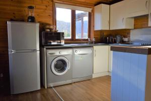 een keuken met een koelkast en een wasmachine bij Woolpack Lodge in Holmrook