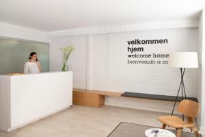 バルセロナにあるエリック ヴェケル ブティック アパートメント BCN スイーツの部屋のフロントデスクに立つ女性