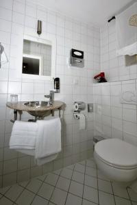 Baño blanco con lavabo y aseo en Liebezeit - ehemals Hotel Dillenburg en Dillenburg