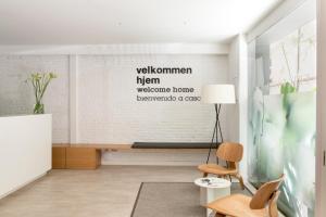a living room with a wall with a welcome sign at Eric Vökel Boutique Apartments - BCN Suites in Barcelona