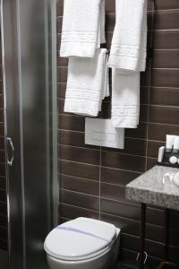 a bathroom with a toilet and white towels at Dark Boutique Hotel in Tirana