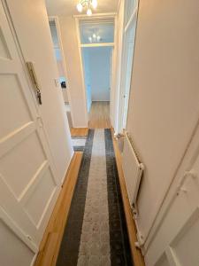 un pasillo con una puerta abierta que conduce a una habitación en 303 Alexandra Avenue HA2 9DX en Pinner