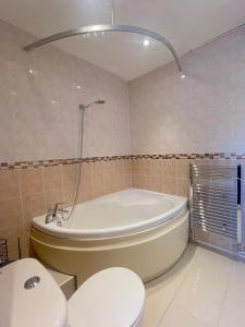 a bathroom with a tub and a toilet and a sink at 303 Alexandra Avenue HA2 9DX in Pinner