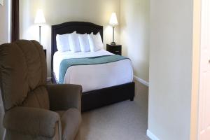 a hotel room with a bed and a chair at Lakeview Golf Resort Townhouses in Morgantown