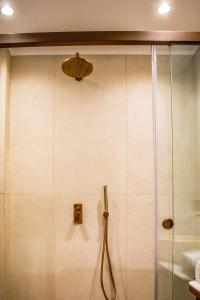 a shower in a bathroom with a glass door at Mandraki Village Boutique Hotel in Koukounaries