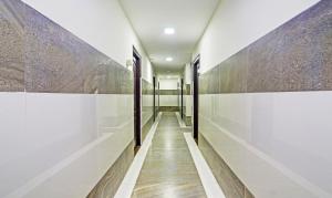 a hallway of a building with white walls and wooden floors at Itsy Hotels Infinity, Hitech City in Hyderabad