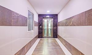 a hallway of a bathroom with white walls and a door at Itsy Hotels Infinity, Hitech City in Hyderabad