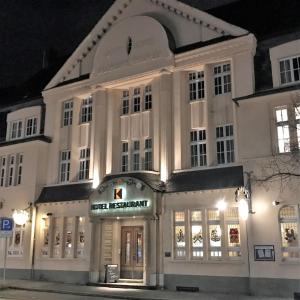 ヴェルネ・アン・デア・リッペにあるStadthotel Im Kolpinghausの目の前に看板が立つ白い大きな建物