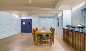 a dining room with a wooden table and chairs at Itsy By Treebo - Infinity Hitech City in Hyderabad