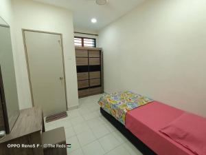 a bedroom with a bed and a dresser at Homestay Sofiyyah 1 in Temerloh