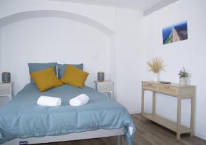 Un dormitorio con una cama azul con almohadas amarillas en Gîte Villa Paul Herm, en Herm