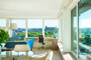 ein Wohnzimmer mit einem blauen Sofa und einem großen Fenster in der Unterkunft COMO Metropolitan London in London