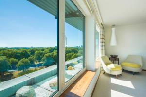 a room with a large window with a couch and a chair at COMO Metropolitan London in London