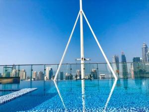 une piscine avec vue sur les toits de la ville en arrière-plan dans l'établissement Luxury Modern Studio in JLT with Amazing View & Rooftop Pool - sleeps 3, à Dubaï