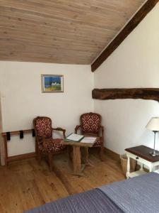 a bedroom with a table and two chairs and a bed at Chambres d'hotes des Forets in Écuras