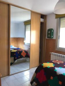 einen Spiegel in einem Schlafzimmer mit einem Bett und einem m2 großen Bett in der Unterkunft Apartamento cuatro vientos con wifi para trabajar in Navás