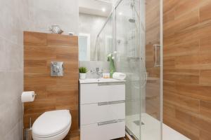 a bathroom with a toilet and a glass shower at Apartments The View by Renters in Warsaw