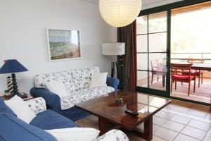 a living room with a blue couch and a table at Pueblo Mascarat con vista al mar in Altea la Vieja
