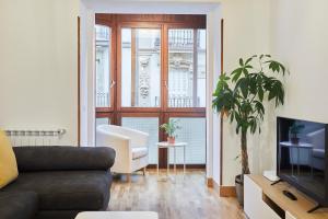 ein Wohnzimmer mit Sofa und Fernseher in der Unterkunft Txindoki by Basque Homes in San Sebastián