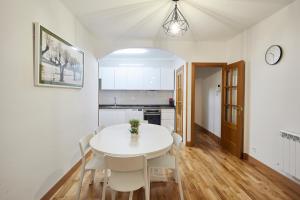eine Küche und ein Esszimmer mit einem weißen Tisch und Stühlen in der Unterkunft Txindoki by Basque Homes in San Sebastián
