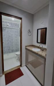 een badkamer met een douche, een wastafel en een toilet bij Apartamento Com Churrasqueira Maranduba Ubatuba! in Ubatuba
