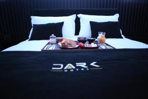 een dienblad met eten en drinken op een bed bij Dark Boutique Hotel in Tirana