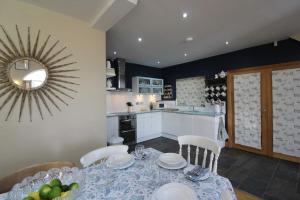 a dining room with a table and a kitchen at The Old Methodist Chapel in Great Massingham