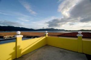 een geel gebouw met uitzicht op het water bij Luis Bay Travellers Lodge in Coron