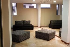 a living room with couches and ottomans at Departamento luminoso amplio y silencioso. in Rosario