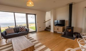 a living room with a couch and a fireplace and a television at 15 - 3 Bedroom Cottage - LP in Nefyn