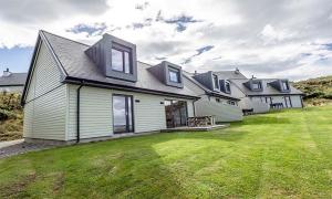 a large white house with a grass yard at 15 - 3 Bedroom Cottage - LP in Nefyn
