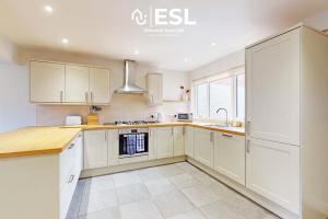 a kitchen with white cabinets and a sink at 5 Bedroom House - Ideal for Groups & Contractors in Shrewsbury