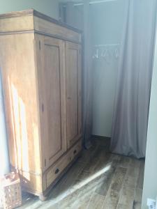 une armoire en bois dans l'angle d'une pièce dans l'établissement Chambre d hôtes Cabries Calas 5 min gare TGV Aix, à Cabriès