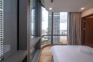um quarto de hotel com uma cama e janelas grandes em THE LANDMARK 81-VINHOMES LUXURY em Ho Chi Minh