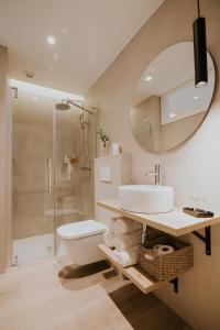 y baño con lavabo, aseo y espejo. en Casa La Picuda, en San Vicente de la Sonsierra
