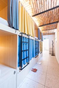 a hallway with blue and yellow curtains and shoes at Boutique Hostel Angel in Ljubljana