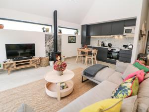 a living room with a couch and a fireplace at Overlea Coach House in Birch Vale
