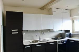 kuchnia z białymi szafkami i zlewem w obiekcie Modern 3BR Near Santa Maria Novella Station we Florencji