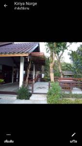 a picture of a building with benches and trees at LUCKY PAI Resort&Hostel in Pai