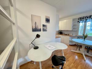 Dieses weiße Zimmer verfügt über einen Tisch und einen Schreibtisch. in der Unterkunft Porvoon Kartanonpuisto in Porvoo