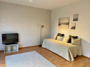 a bedroom with a bed and a flat screen tv at Porvoon Kartanonpuisto in Porvoo