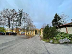 eine leere Straße mit einem Gebäude und Bäumen und Sträuchern in der Unterkunft Porvoon Kartanonpuisto in Porvoo