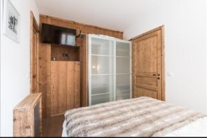 a bedroom with a bed and a sliding glass door at Résidence Chalet des Coeurs in Notre-Dame-de-Bellecombe