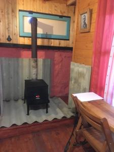 una stufa a legna in una stanza con una parete in legno di Guesthouse AISI in Lagodekhi a Lagodekhi